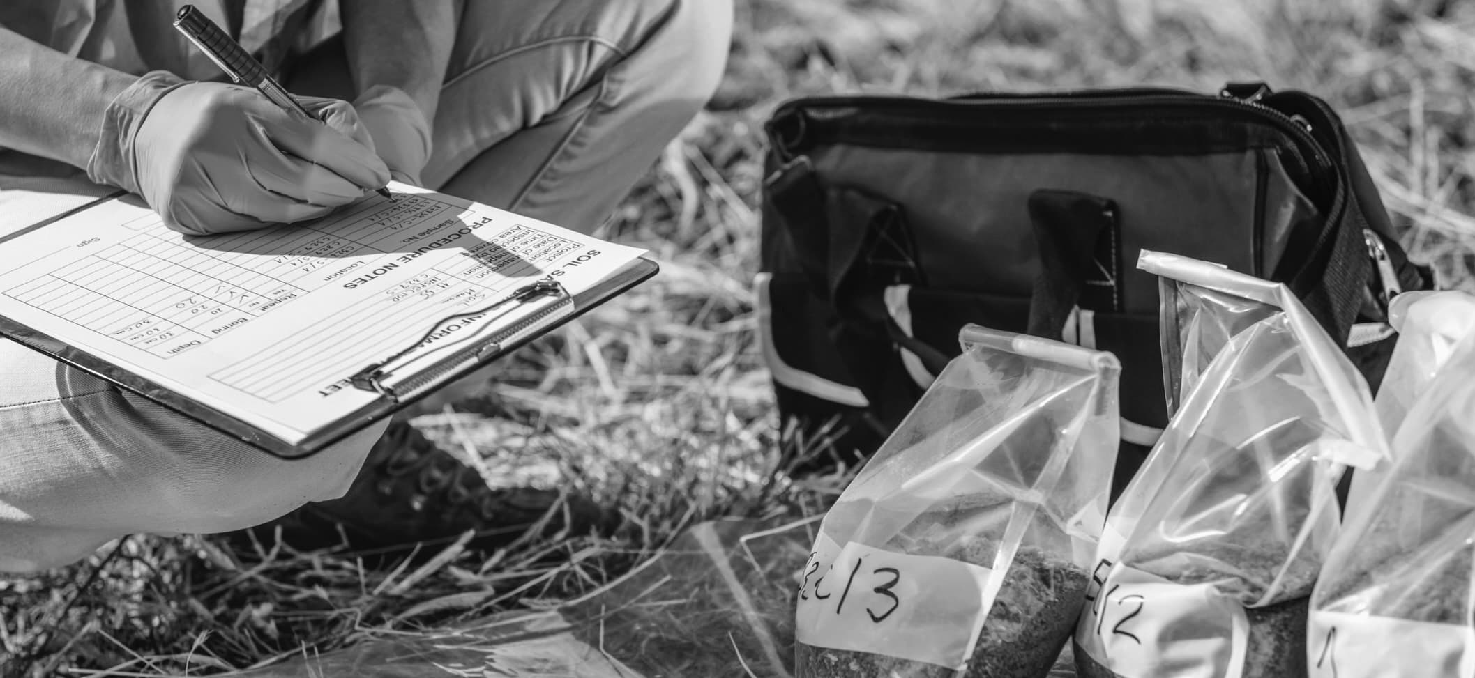 Technicien Soletec renseignant la fiche terrain à côté des sacs d'échantillons de sol prélevés lors d'un sondage géotechnique